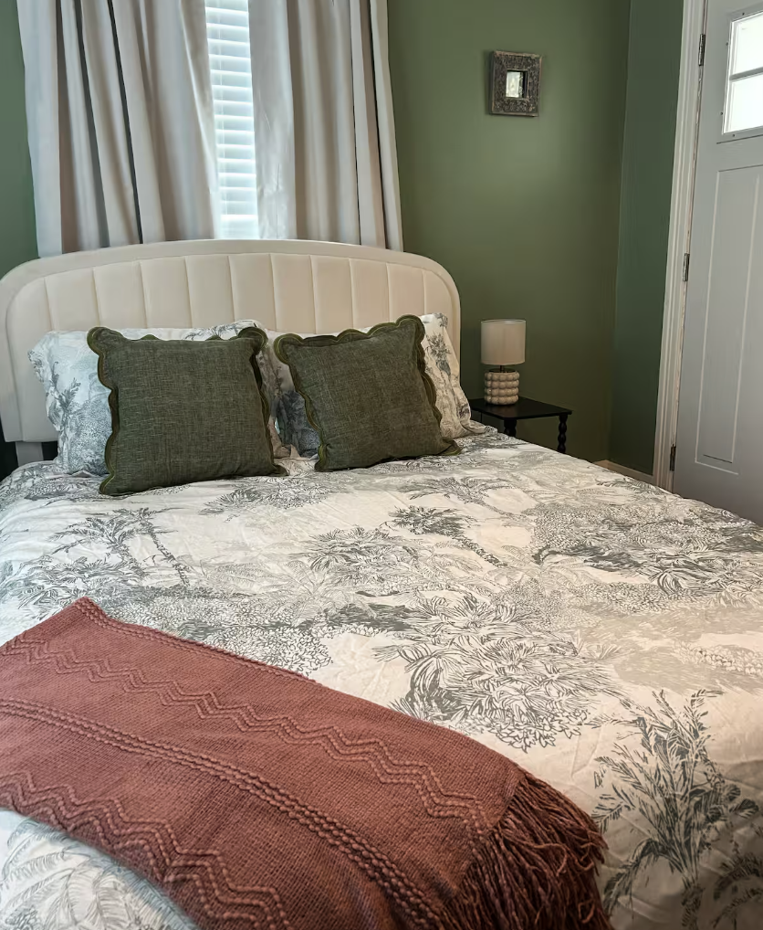 Queen bedroom with green walls and toile bedding