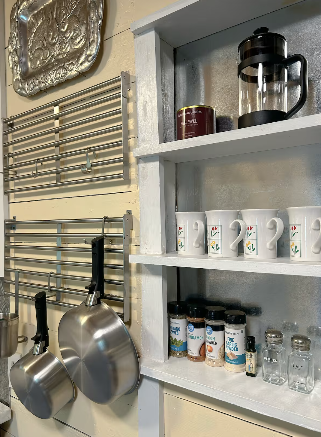 Stocked shelves with French press, mugs, and spices