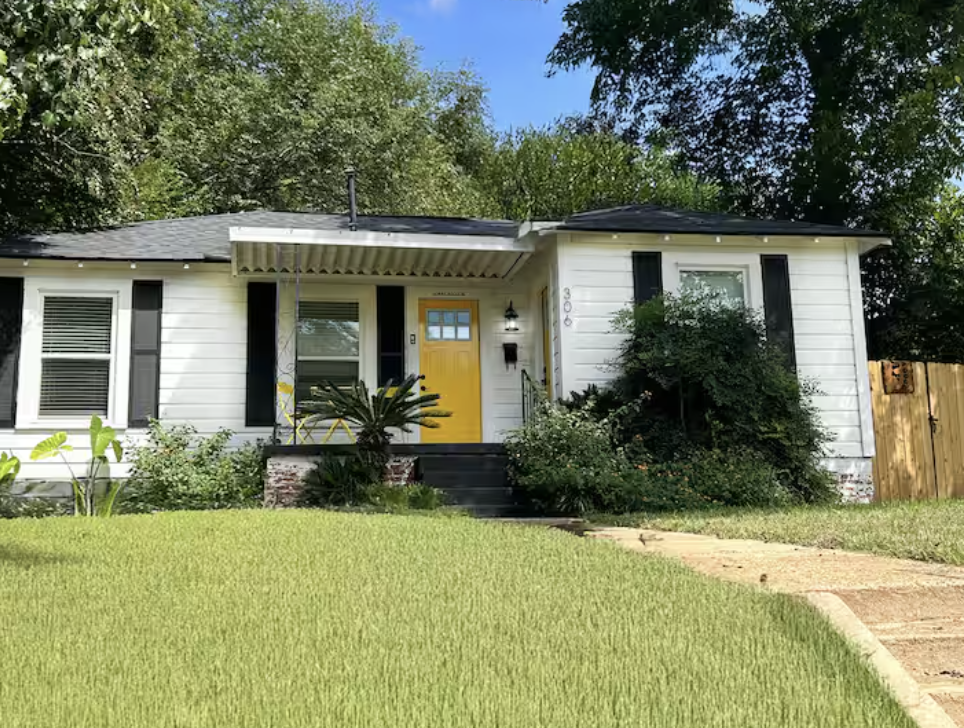 White cottage exterior with yellow front door