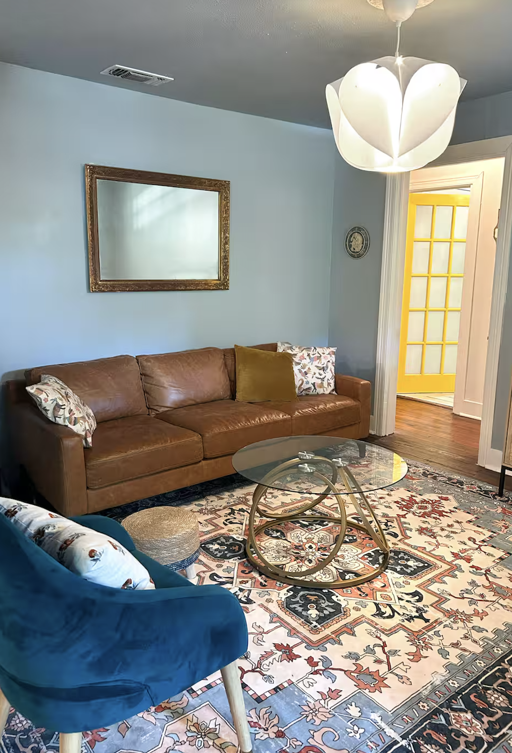 Bright living room with leather sofa and Persian rug